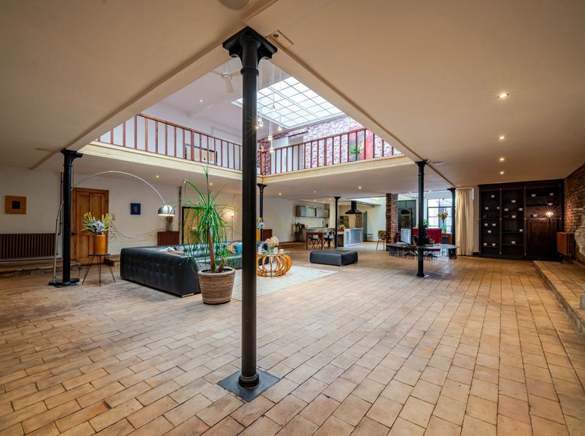 Ontdek deze gerenoveerde voormalige textielfabriek (industriële charmante loft met terras, oprit en parking, en groot atelier), gelegen in het centrum