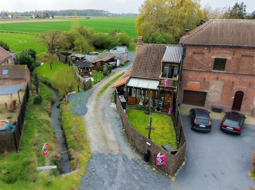 Découvrez cette maison atypique de style chalet située dans le charmant village de Blandain. Elle offre un séjour de 30 m² et une véranda de 11 m², un