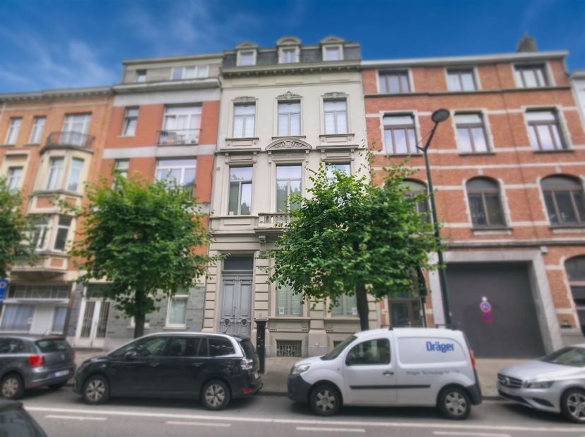 Zeer karaktervol appartement met 2 slaapkamers, 2 badkamers en garagebox te koop in een prachtig herenhuis in Laken! Het appartement is goed onderhoud