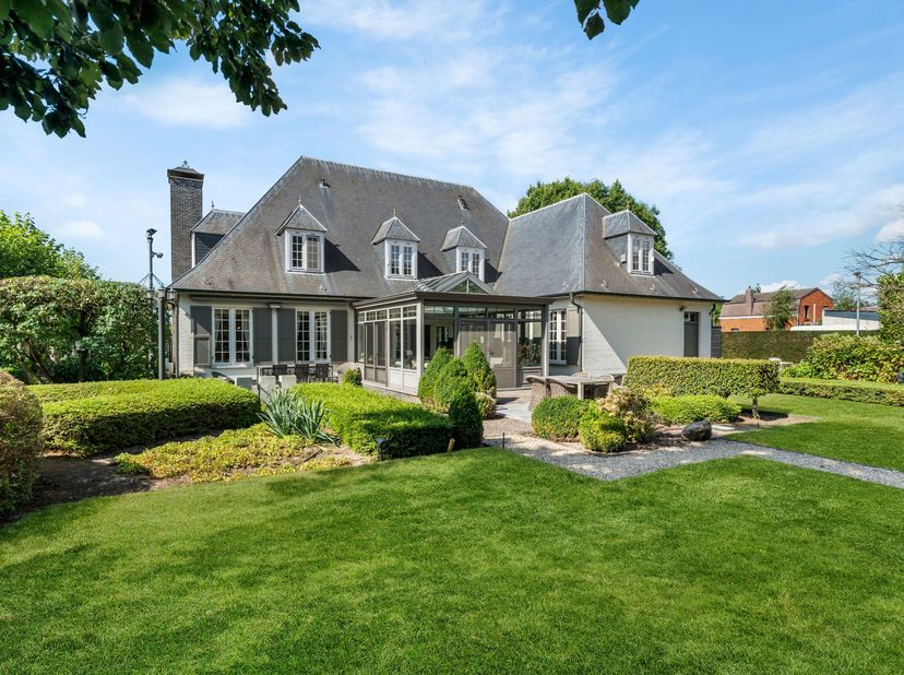 Deze verzorgde villa is gelegen op een groen maar centraal gelegen perceel van +/- 2.081 m². Ze omvat een ruime woonkamer, keuken met veranda, bureau,