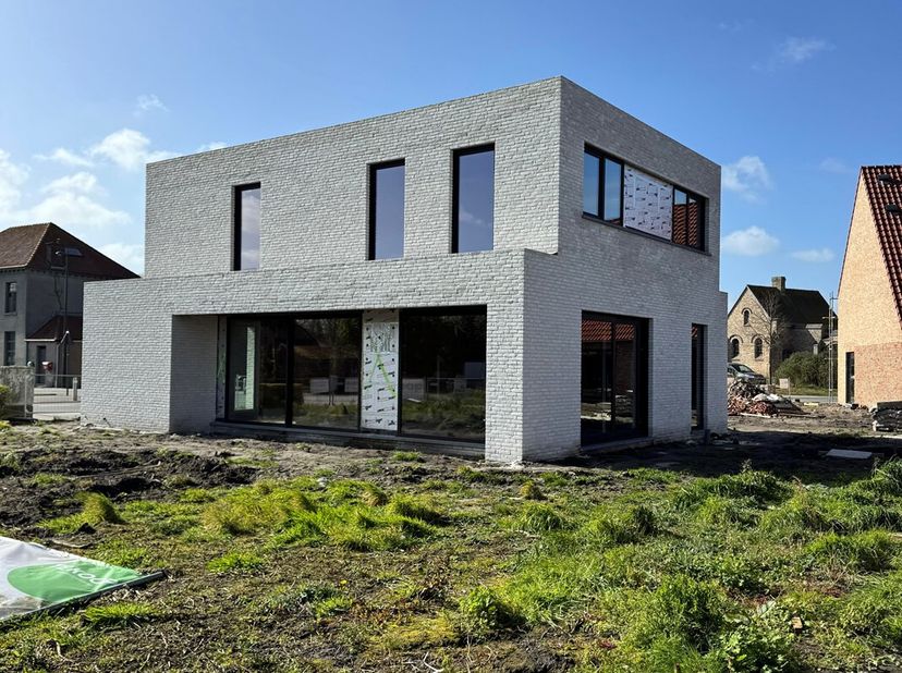Deze nieuwbouwwoning is gelegen te Zande en bestaat uit:<br />
Gelijkvloers: inkomhal - gastentoilet - lichtrijke living met open ingerichte keuken -