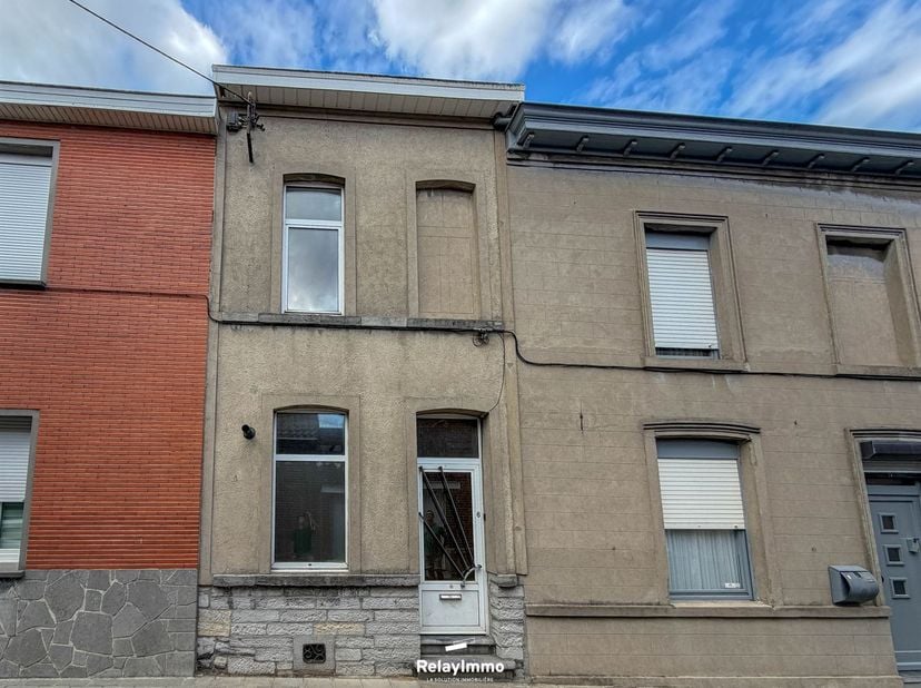 Située à Antoing, rue à Châpons 6, cette maison mitoyenne à rénover offre une configuration intéressante avec deux chambres, une petite cour et une ca