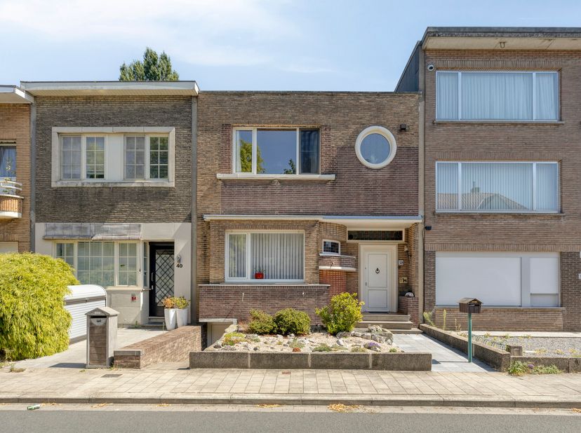 Deze charmante rijwoning is gelegen in de 'Unitaswijk' vlakbij het Boekenberg Park en bestaat uit: voortuin (met toegang tot de kelder), inkom, living