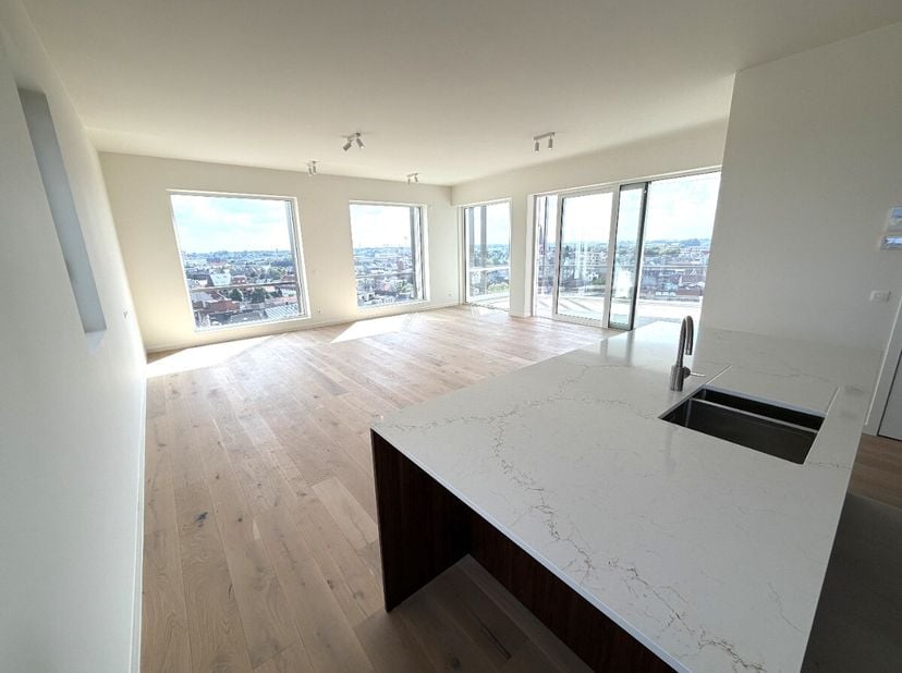 Ontdek dit uitzonderlijk ruime nieuwbouwappartement van maar liefst 122 m² (exclusief terras!) op de tiende verdieping, waar comfort, klasse en een ad