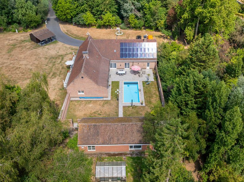 Deze exclusieve eigendom met privé-oprijlaan straalt rust en exclusiviteit uit.<br />
Indeling:<br />
- Inkomhal met gastentoilet en vestiaire.<br />