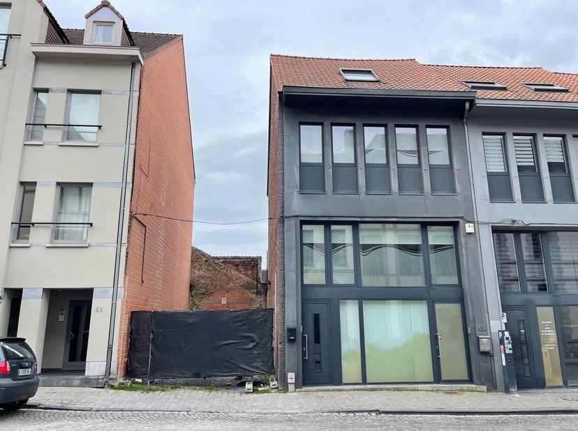 Commerciële ruimte van 150m² met tuin, kelder en 50m² bouwgrond op een TOPLIGGING in Doornik, vlakbij de Grote Markt. Deze handelsruimte biedt een rui