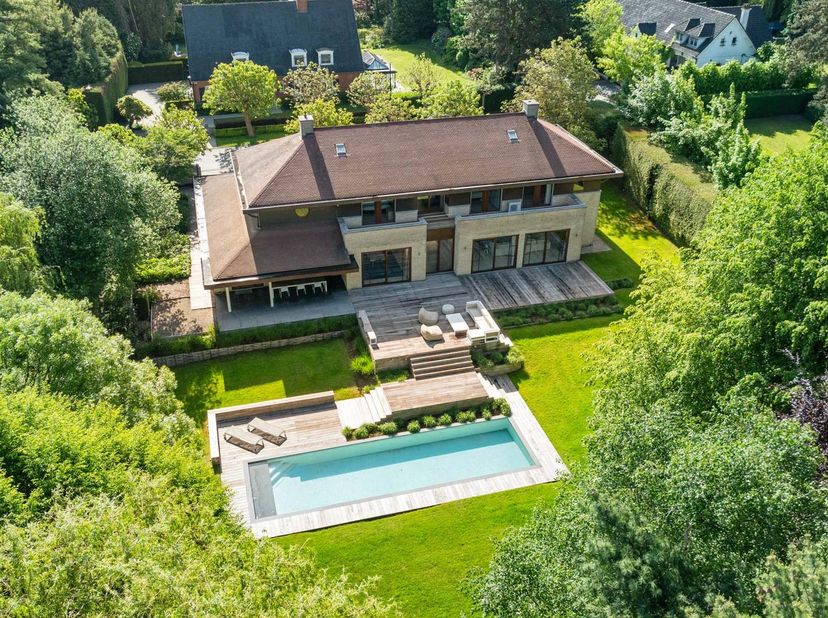 Gelegen in een uiterst rustige laan in het prestigieuze Domein van Bouchout te Wemmel, biedt deze groots opgezette villa hypermodern wooncomfort waar