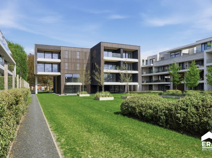 Ruime penthouse met zicht op de binnentuin en de Ieperse torens. Inkom met apart toilet. Ruime living met open keuken. Overdekt terras met zicht op de
