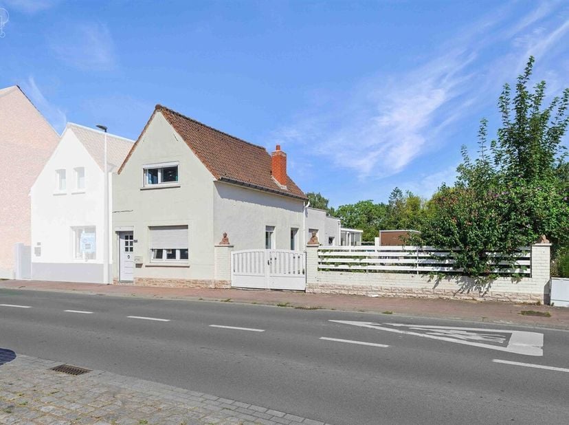 Mooi, grotendeels gelijkvloers huis met drie gevels, garage en zijtoegang, gelegen op een perceel van ongeveer 1.415 m², waarvan een deel nog bebouwba