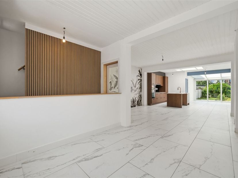 In een van de rustigste straten van Mechelen, ligt dit vernieuwde huis. De gevel met witte sierpleister is onderaan voorzien van een plint in blauwe h