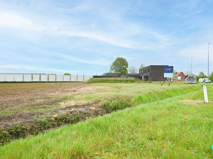 Deze gunstig gelegen bouwgrond van 1102 m² biedt de ideale combinatie van wonen en werken. Gelegen langs de Ringlaan (N50) geniet het perceel van een