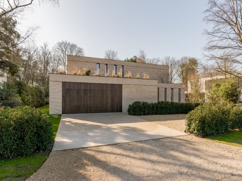 Luxueuze villa te koop. Op het gelijkvloers is een dubbele garage, een ruime wasplaats een living met tuinzicht en aanpalend een open keuken voorzien.