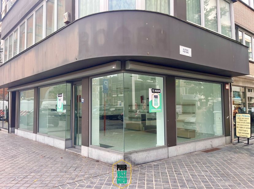 Recent vernieuwde handelsgelijkvloers met 55 m² winkel met fantastische hoeketalage (aan pleintje) + 30 m² stockage extra, en ook sanitair op kelderni