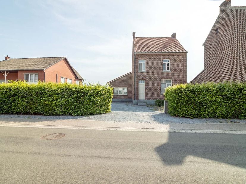 WONING MET TUIN<br />
<br />
Woning (OB) met ruime tuin, groot 10a 70ca, omvattende:<br />
- gelijkvloers: inkomhal met trap naar boven, living met pa