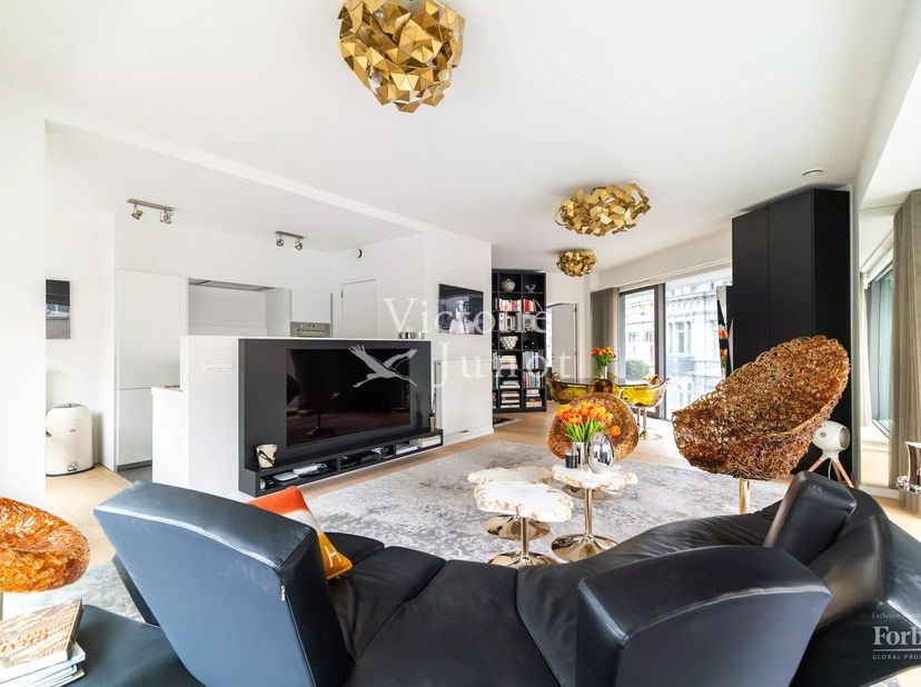 Gelegen op de prestigieuze Louizalaan, in de onmiddellijke nabijheid van het Ter Kamerenbos, bevindt dit elegante appartement zich op de tweede verdie