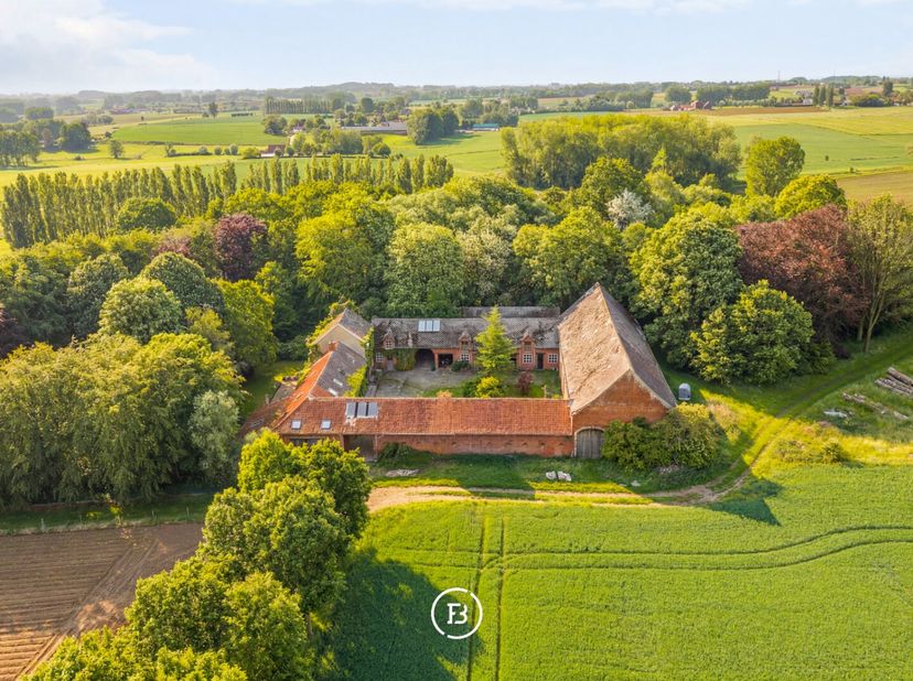 Te midden van een prachtig groen domein van ca. 3 hectare, bereikbaar via een lange private dreef, bevindt zich deze authentieke rustieke vierkantshoe