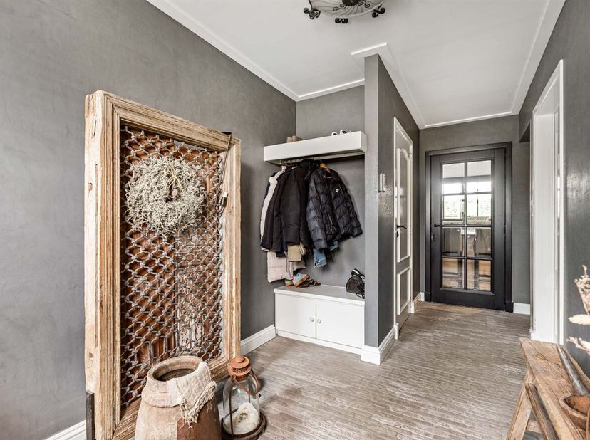 Bij het binnenkomen komt u terecht in een verzorgde inkomhal met voldoende plaats voor een vestiaire en een gastentoilet. Verder opent de woning zich
