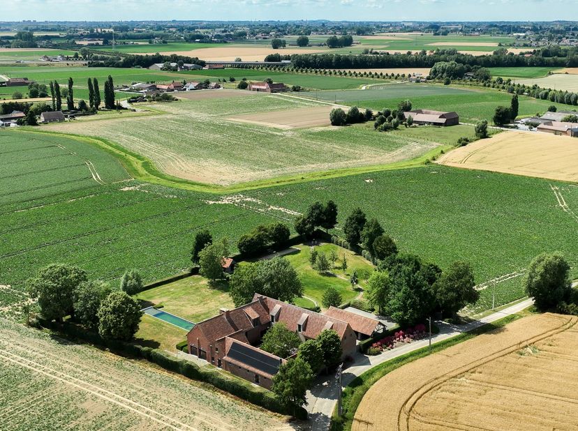 Dans un environnement verdoyant au cœur d’une zone agricole, découvrez cette superbe ferme en carré entièrement rénovée avec des matériaux nobles et u