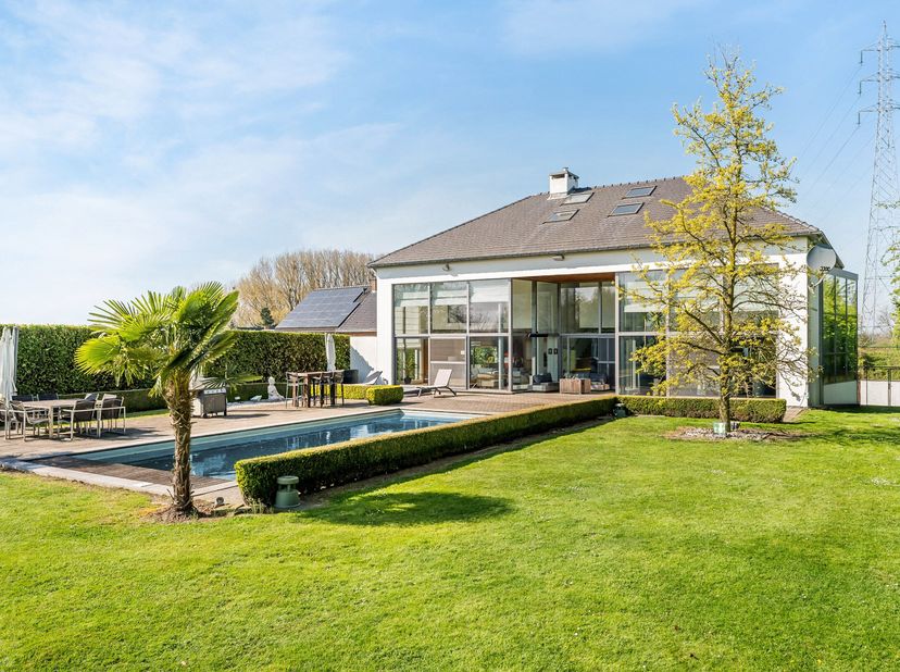 Gelegen aan de Maastrichterstraat in Bilzen, biedt deze uitzonderlijke villa een oase van luxe en rust op een perceel van ca. 15.000 m². De ligging co
