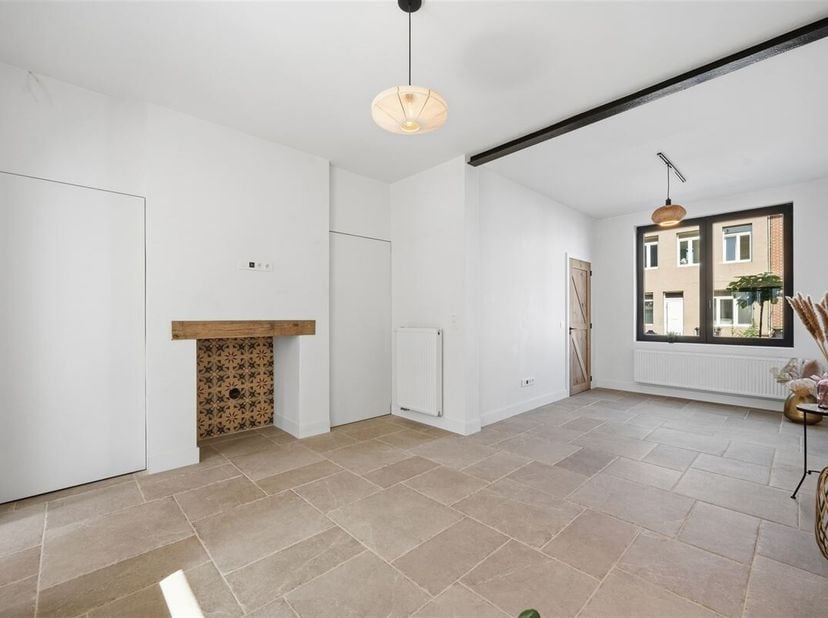 Deze woning met wit geschilderde gevel, ligt in een rustige éénrichtingsstraat (zone 30). Het gunstige EPC-label B, werd behaald door: achtergevelisol