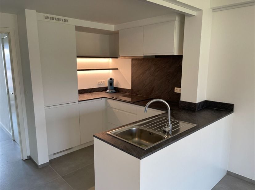 Mooi en rustig gelegen appartement in het centrum van Kortrijk.  Inkom met vestiaire, living, open ingerichte keuken met koelkast, diepvries, vaatwas,