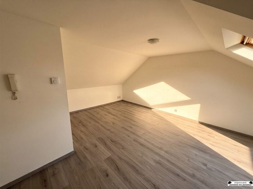 Charmant appartement mansardé dans le centre de Wuustwezel ! <br />
Agencement :<br />
Salon de 30 m² avec sol stratifié. <br />
Cuisine semi-ouverte