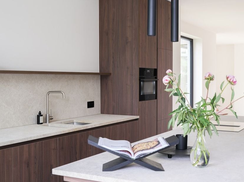 Via een charmant golvend klinkerpad bereik je de inkomhal met gastentoilet. De lichtrijke eetruimte en gezellige living met zwevende trap en ingewerkt