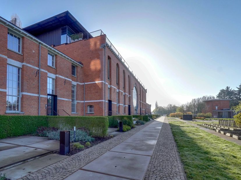 Dit penthouse met een ondergrondse parking en kelderberging bevindt zich in een karaktervol gebouw dat vroeger dienst deed als chocoladefabriek en met