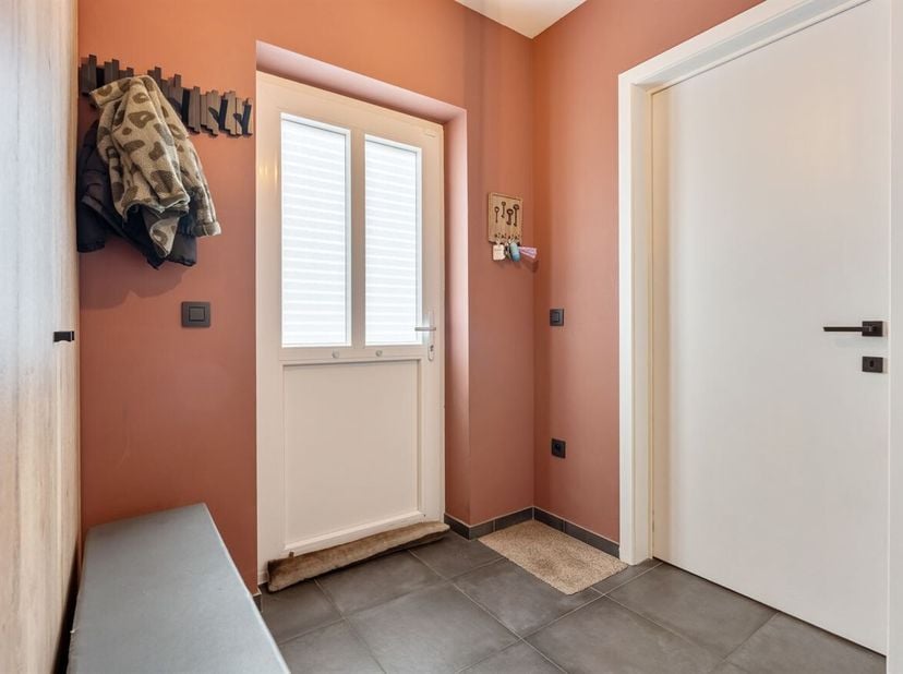 La maison, construite en 2021, vous accueille par un hall d'entrée avec des toilettes séparées pour les invités. Depuis le hall, vous entrez dans le s