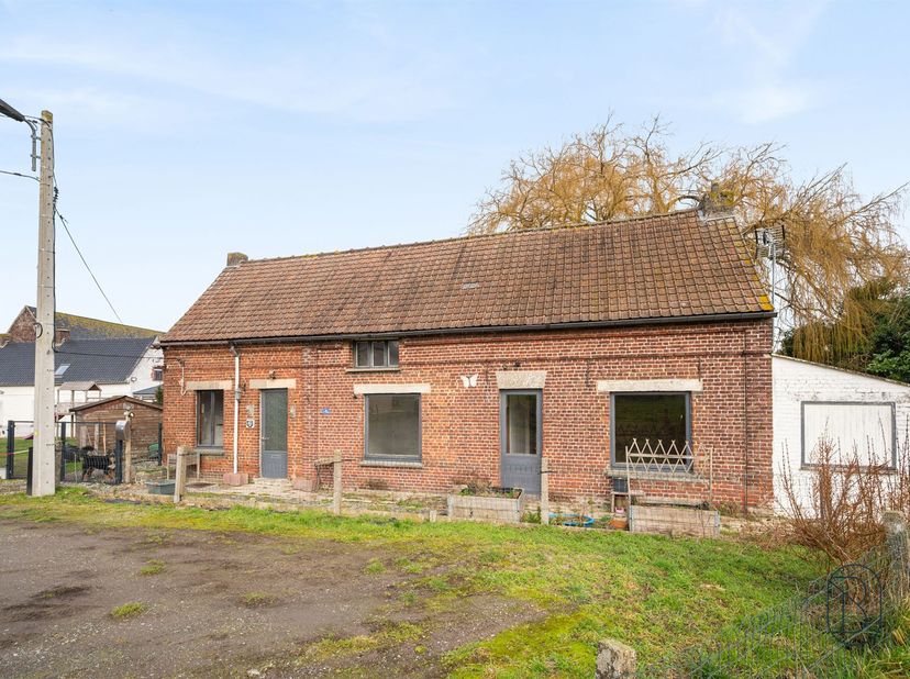 Gelegen in een doodlopende straat van het rustige dorp Guignies, is deze volledig te renoveren viergevelwoning gebouwd op een perceel van 620 m² en bi