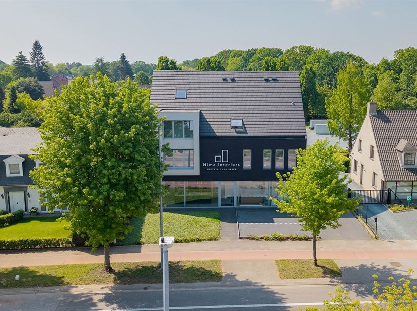 Exclusief gebouw te Borsbeek - ideale showroom/kantoor/praktijkruimte met bovenliggende woonst en achterliggend magazijn op ca 2.139 m².<br />
Dit uni