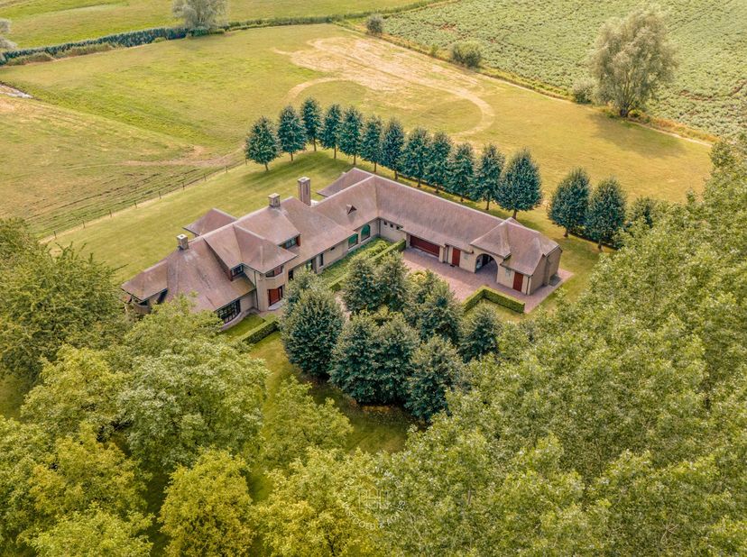 Te midden van het groen en de rust van Mendonk bevindt zich deze exclusieve villa op een domein van ca. 7 hectare, waar ruimte en natuur harmonieus sa