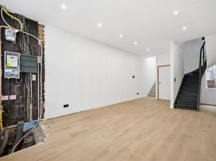 En plein cœur de la ville se trouve cette maison récemment rénovée, avec sa façade peinte en blanc et ses hauts plafonds. Tant les installations techn