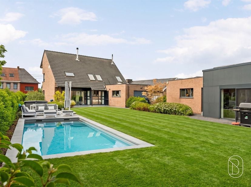 Découvrez cette maison aux finitions haut de gamme située à Anzegem, sur un terrain de 1 450 m². Avec une surface habitable de 252 m², une piscine, un