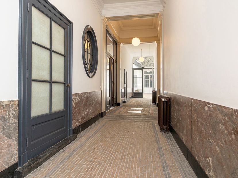 Gelegen in het hartje van Antwerpen, verscholen achter de iconische gevel van De Witte Lelie, betreedt u een uitzonderlijk ruim appartement in een maj