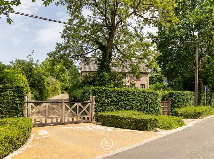 Een tijdloze villa in Genk, verscholen in het groen op een omheind perceel van 42 are. Achter de karaktervolle gevel in Vlaams kruisverband ontvouwt z