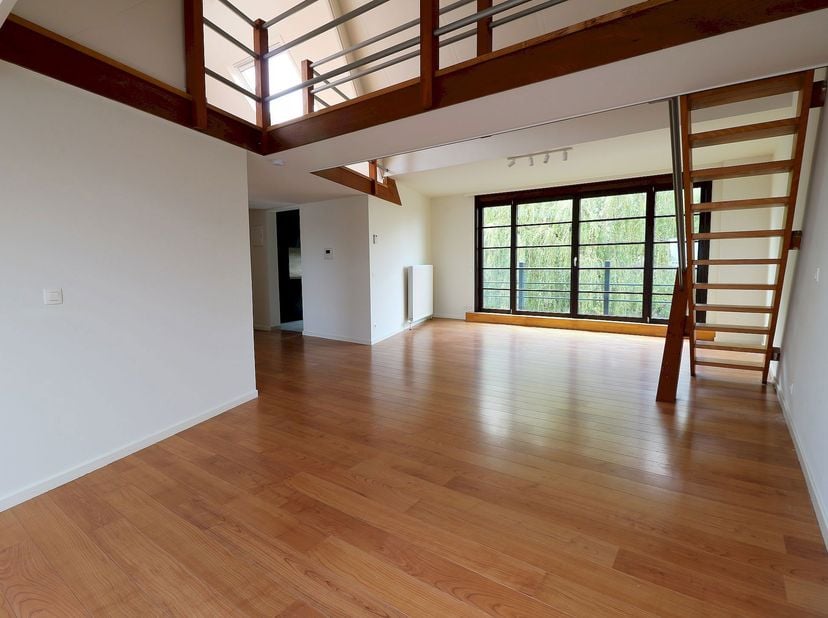 Lichtrijke penthouse gelegen in een klein gebouw en samengesteld uit:<br />
• Ruime leefruimte van ±35 m² met salon- en eetgedeelte<br />
• Volledig u