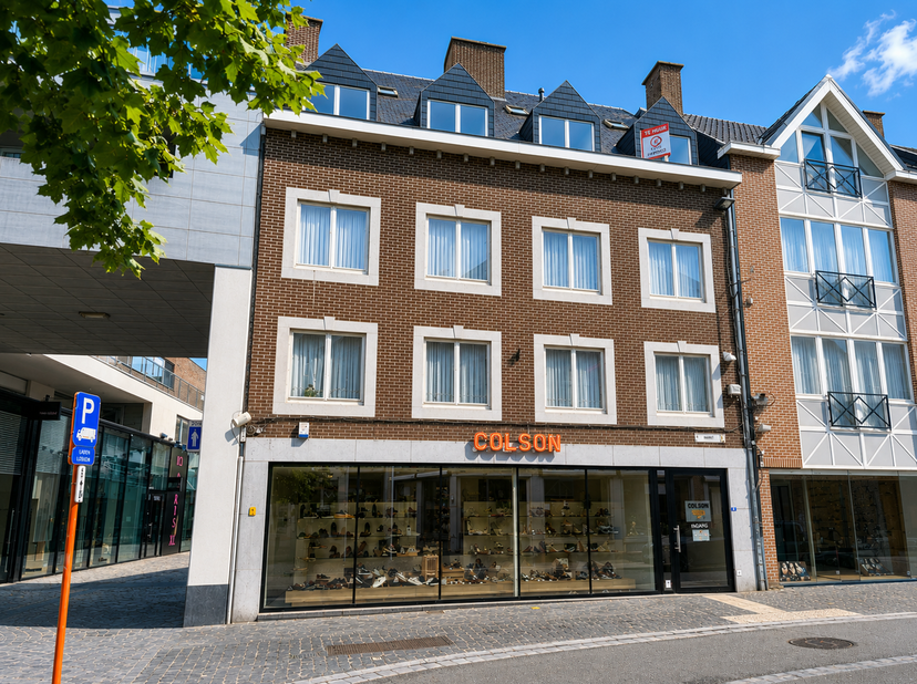 Ruim appartement (116 m²) met veel lichtinval gelegen in het centrum op de markt van Bilzen<br />
Indeling<br />
+ Inkomhal<br />
+ Grote woonkamer me