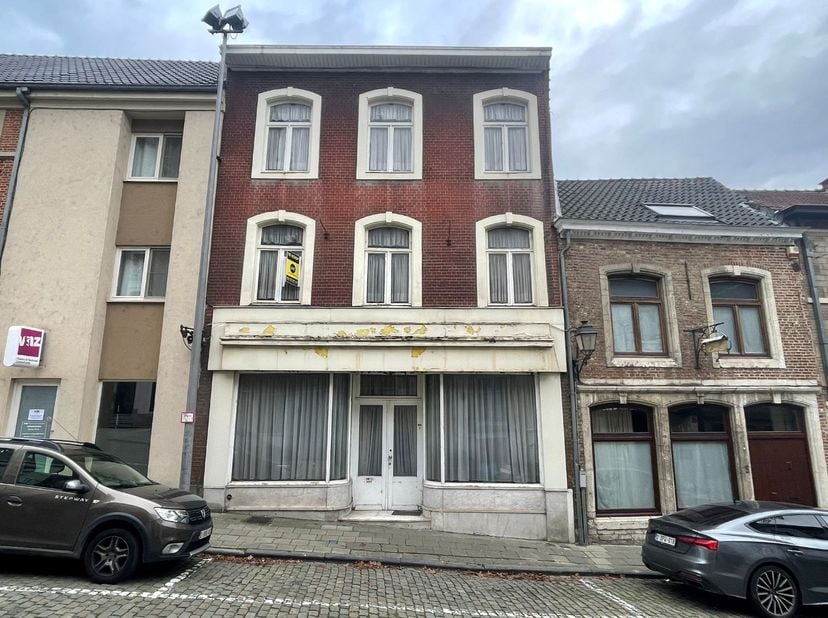 Rijwoning, ideaal gelegen te Wolmarkt 7 in Tienen. Via de gelijkvloers komen we binnen in een polyvalente, grote ruimte die kan dienen als extra leefr