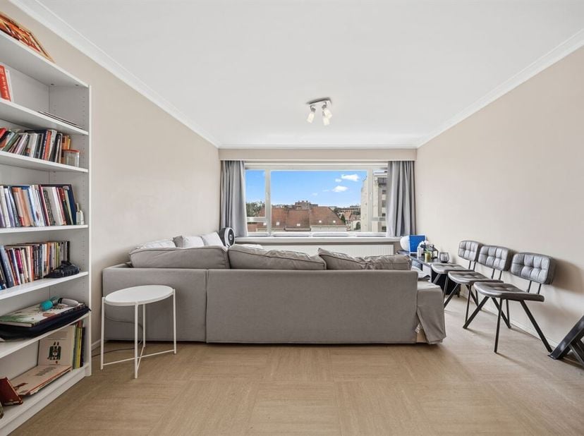 Dit hoekappartement op de vijfde verdieping, ligt aan de minst drukke kant van de Schuttersvest, een brede laan met grote bomen en parkeerplaatsen in