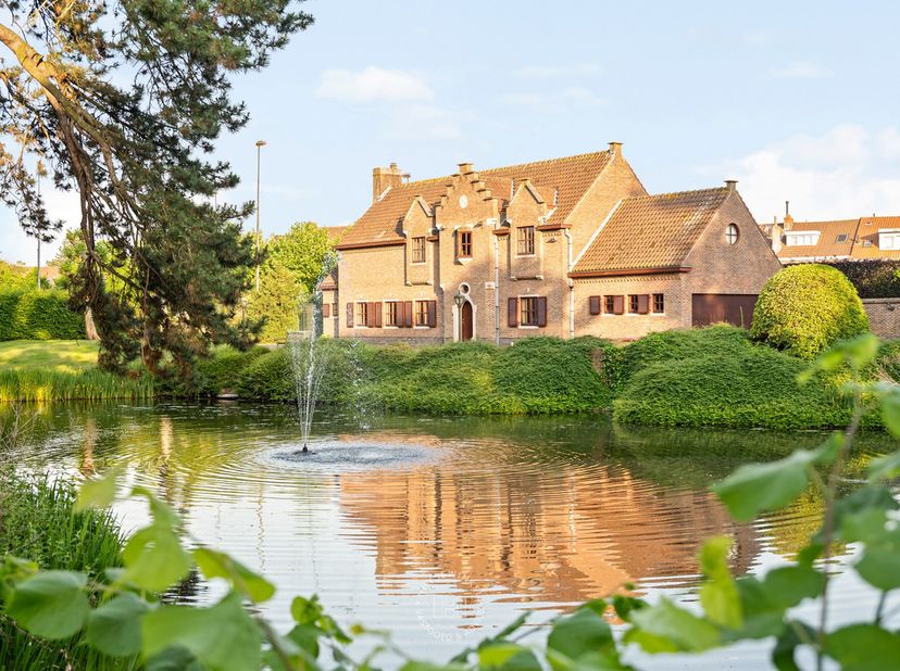 Verscholen in het groen, op een van de mooiste residentiële percelen van Wondelgem, bevindt zich deze statige villa op een indrukwekkend privédomein v