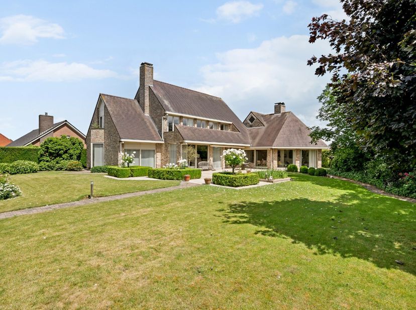- Villa op een groot hoekperceel (2.510 m²)<br />
- Inkomhal met vestiaire en apart toilet<br />
- Ruime leefruimte met parketvloer en gezellige gasha