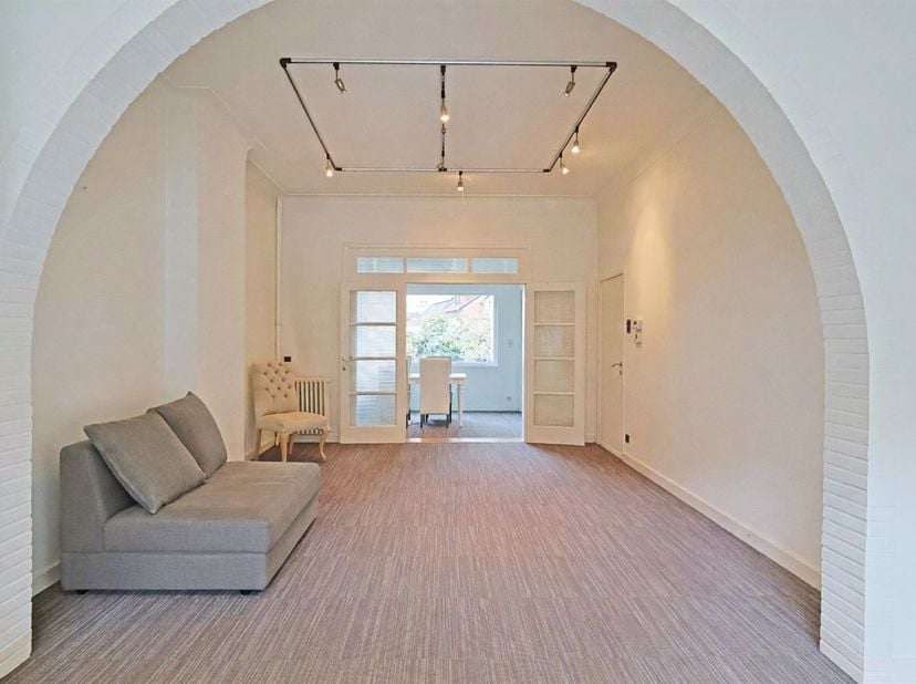 Via een ruime inkomhal met vestiaire en inbouwkasten, komt men in het woongedeelte.<br />
Dit bestaat uit een ruime living, een eetkamer, een leefleu