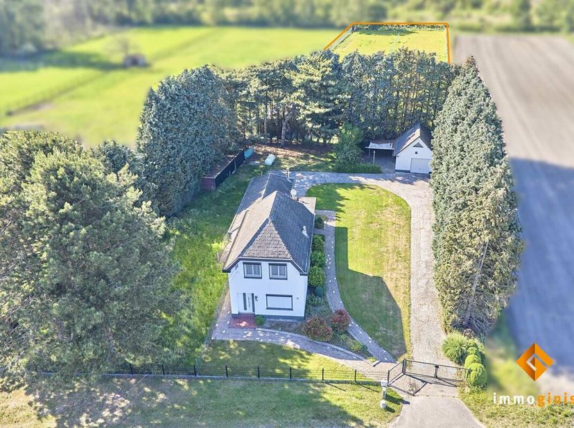 Deze woning is gelegen op een ruim perceel van 59a50ca, omgeven door velden en weilanden en vlakbij het bos.<br />
Indeling gelijkvloers: inkomhal, wo