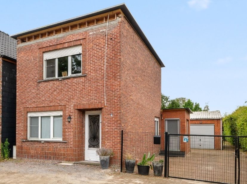 Rustig en gunstig gelegen woning met ruim bijgebouw op een zuidelijk georiënteerd perceel van 5a40ca.<br />
De woning omvat: kelder, inkomhal, living,