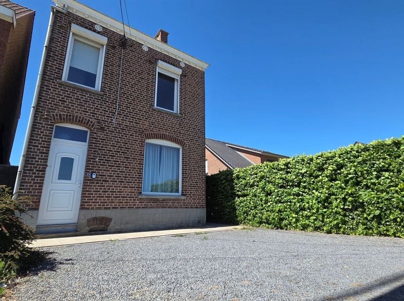 Gelegen aan de ingang van het dorp, in een gegeerde omgeving, vrijstaande woning (4 gevels) met parkeergelegenheid voor twee wagens vooraan. Op het ge