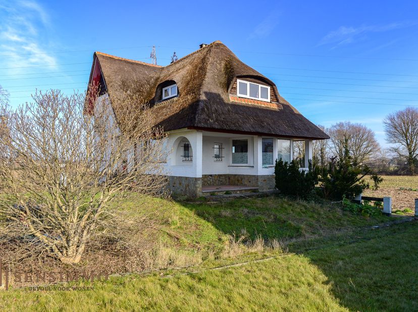 Langs de Rijksweg te Maasmechelen bevindt zich deze charmante vrijstaande woning met een uniek rieten dak en een landelijke uitstraling. De woning gen