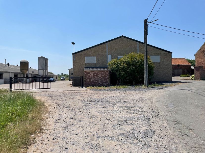Aan de rand van het dorp, grote, vrijstaande loods van ongeveer 317 m² (15,40 m Ã 20,60 m) met een gladde betonnen vloer. Mooie hoogte en grote schuif