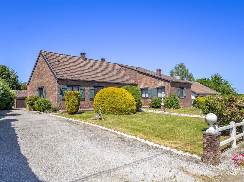 Magnifique plain-pied de 172m2 érigé sur un terrain de 13a57ca, situé dans une rue calme et paisible à Biesmerée. Avec ses deux entrées distinctes, ce