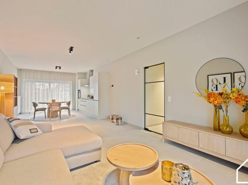Dit nieuwbouwappartement op de 1e verdieping (62m²) bestaande uit een inkomhal met vestiaire en toilet, woonkamer met balkon en ingerichte keuken, 1 s